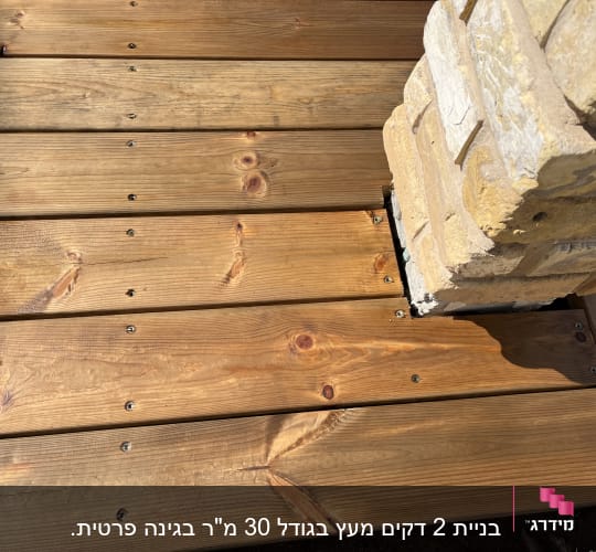 דק עץ עם עמוד אבן בפינה